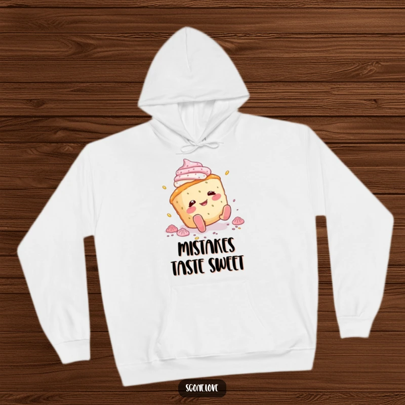 Funny scone hoodie depicting a scone character comically tripping and spilling icing, offering warmth and a good dose of humor.